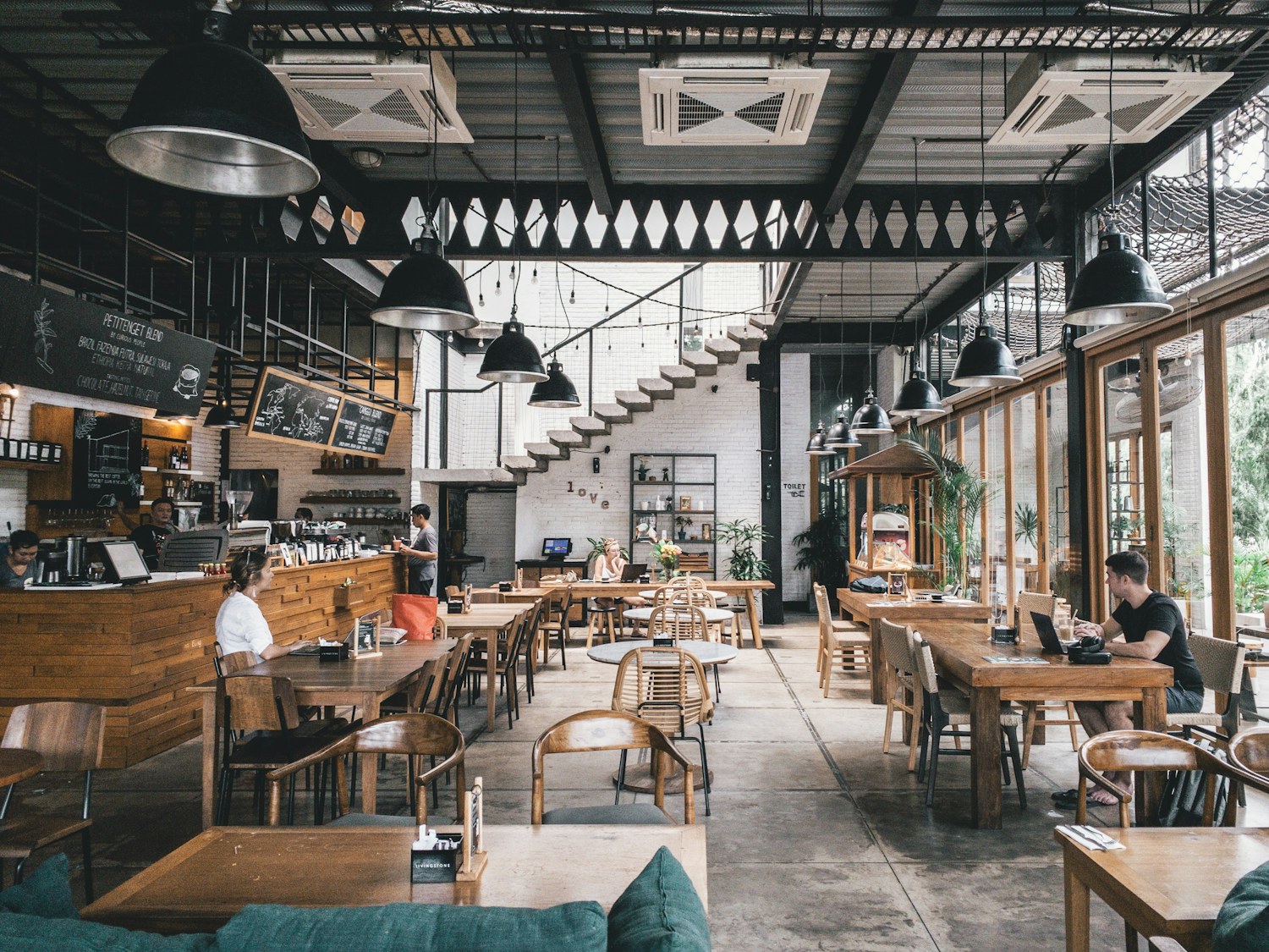 Restaurant with wooden tables, pendant lights and a café counter